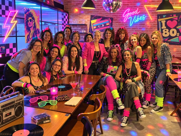 Imagem inspirada na estética dos anos 80, com neon, ombreiras, polainas e cabelos volumosos